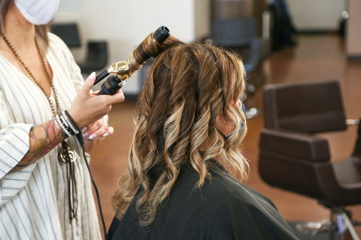 Stylist curling a client's hair
